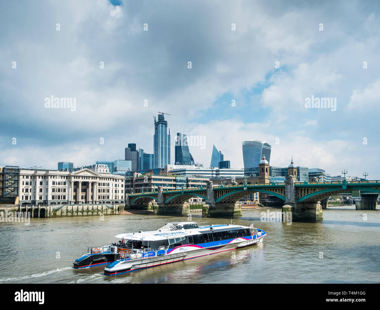 A Thames Clipper barca fluviale sul fiume Tamigi avvicinando Southwark Bridge di Londra. Foto Stock