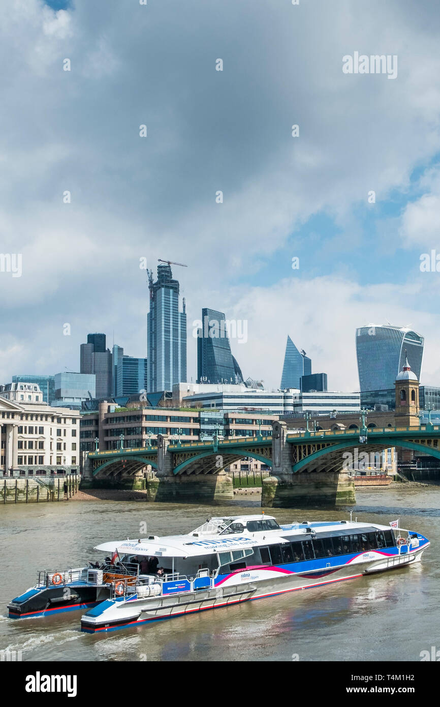 A Thames Clipper barca fluviale sul fiume Tamigi avvicinando Southwark Bridge di Londra. Foto Stock