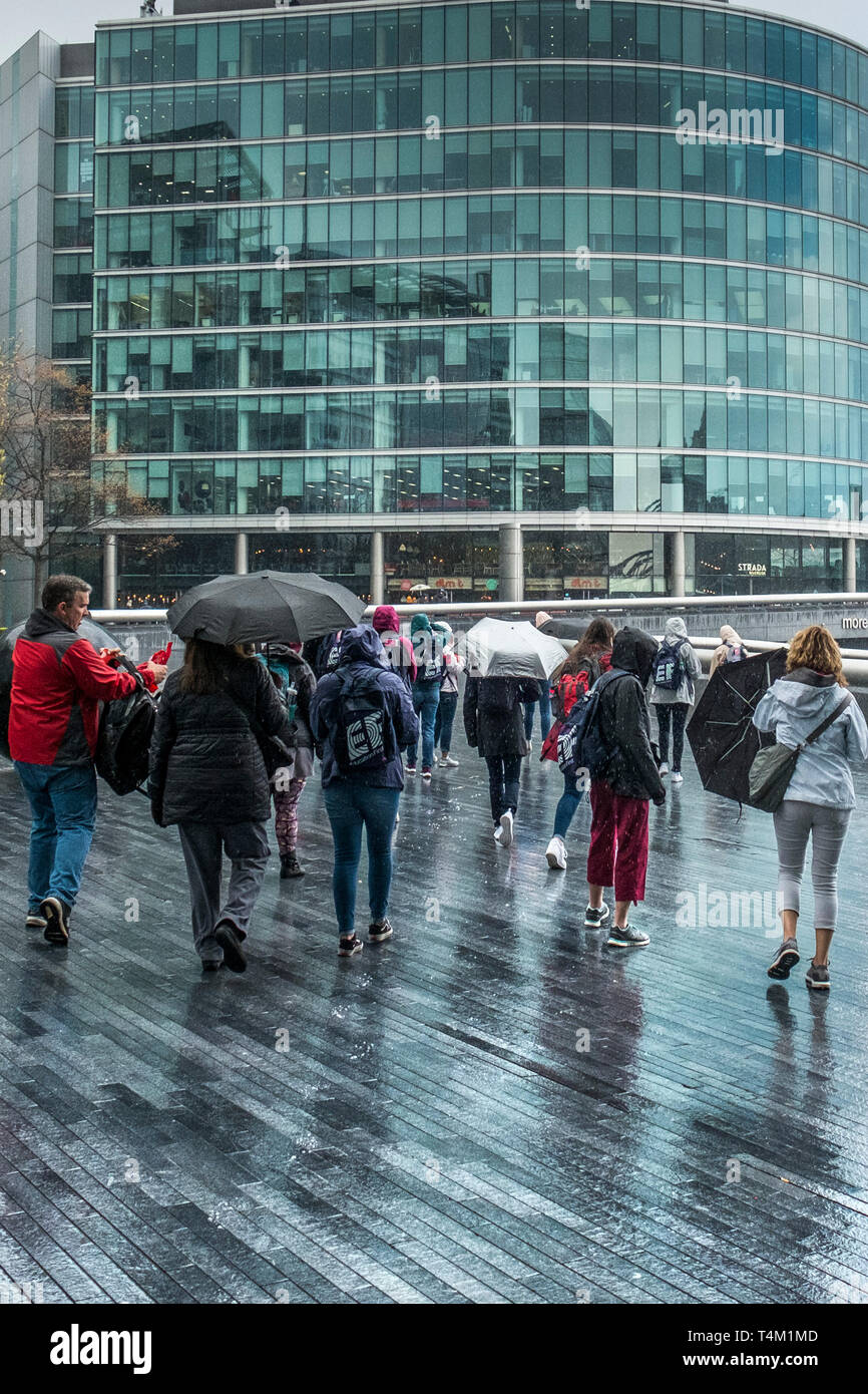 Un gruppo di turisti a piedi attorno al più London development area sulla South Bank di Londra. Foto Stock