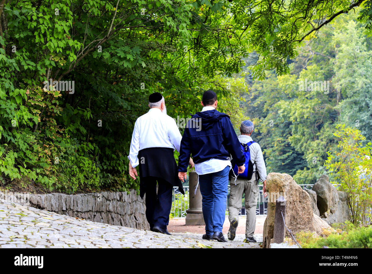 Le persone anziane, un Hasidic ebrei famiglia a piedi nel parco durante l'anno ebraico. Uman, Ucraina Foto Stock