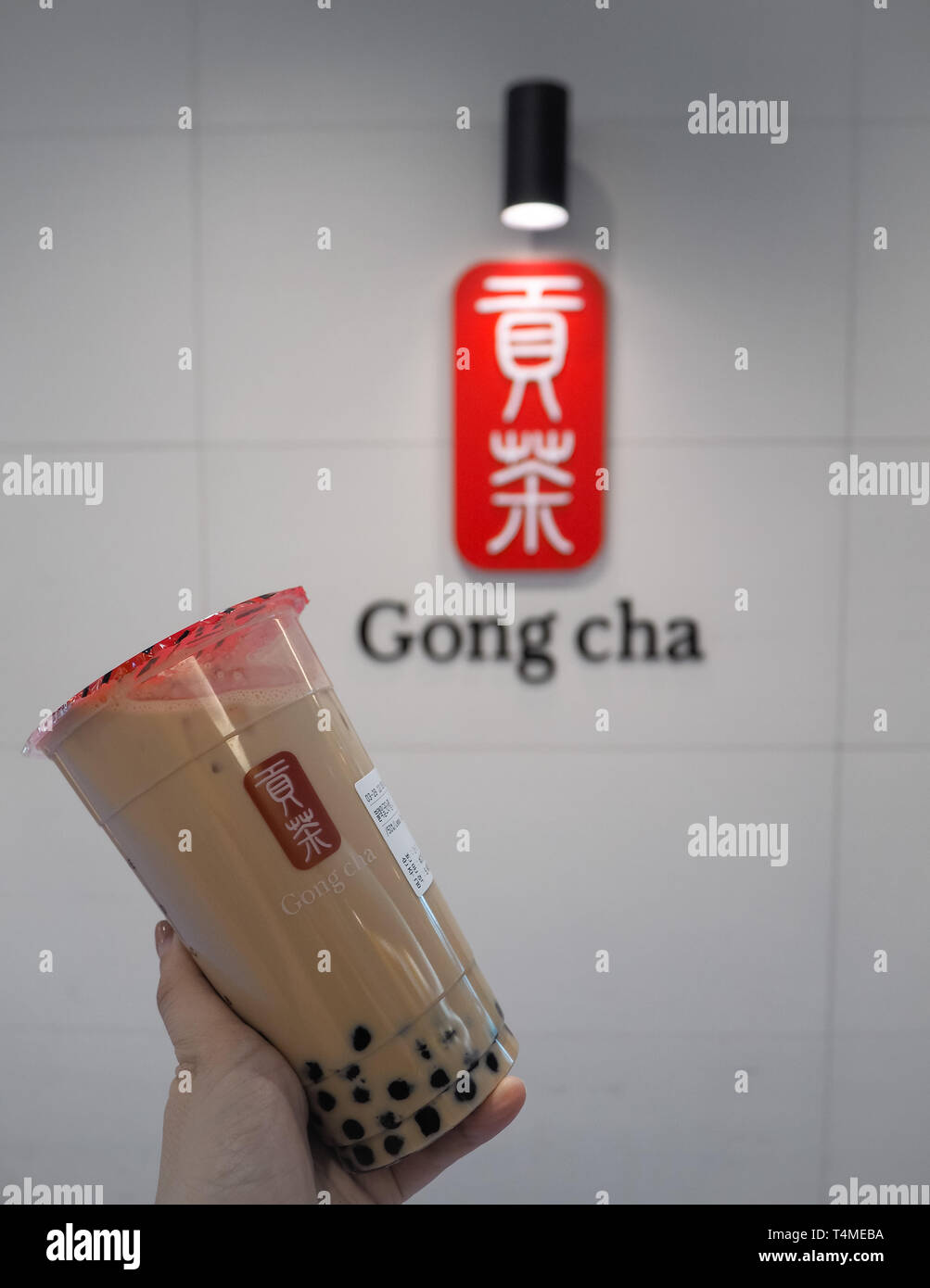Marzo 2019 - Corea del Sud: Caucasica mano femmina tenendo un jumbo dimensioni latte nero tè con perle o bolle di tè dal marchio Taiwanese Gong Cha Foto Stock