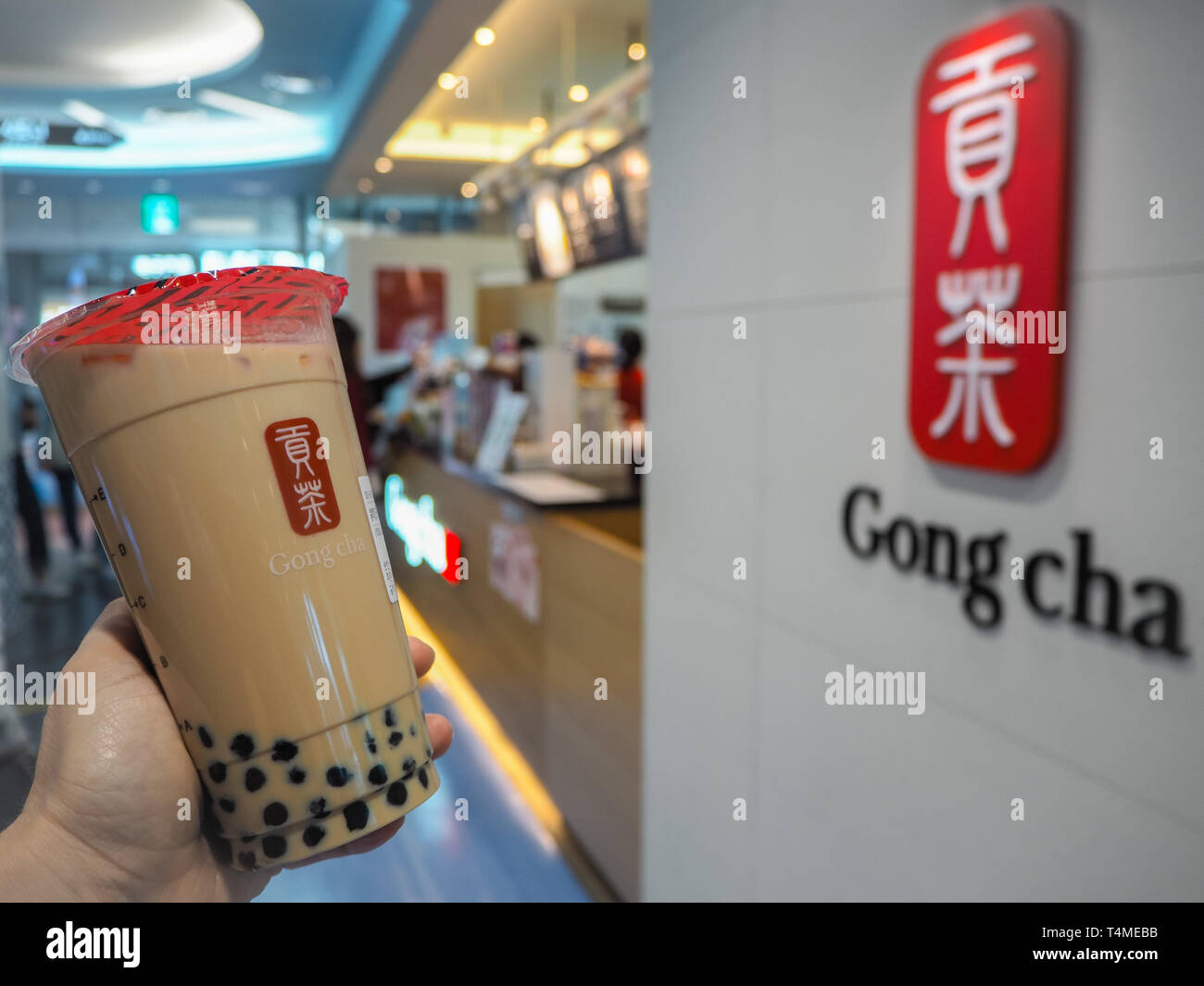 Marzo 2019 - Corea del Sud: Caucasica mano femmina tenendo un jumbo dimensioni latte nero tè con perle o bolle di tè dal marchio Taiwanese Gong Cha Foto Stock