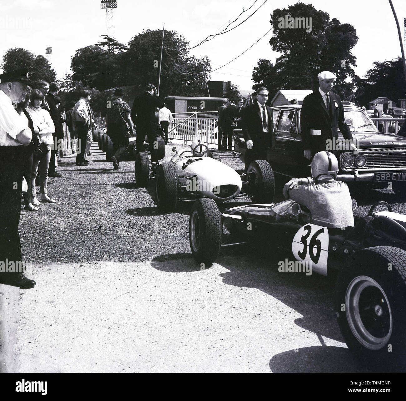 Anni sessanta, storico motor racing al Crystal Palace il circuito di gara nel sud di Londra, London, England, Regno Unito, driver in auto in attesa di entrare in pista. Foto Stock