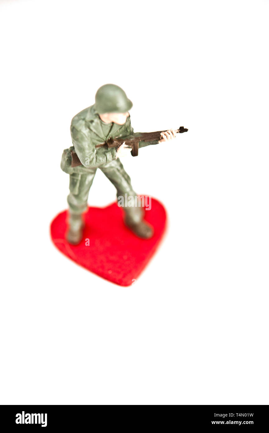 Giocattolo di plastica soldato e forma di cuore, fanno di non amare il concetto di guerra Foto Stock