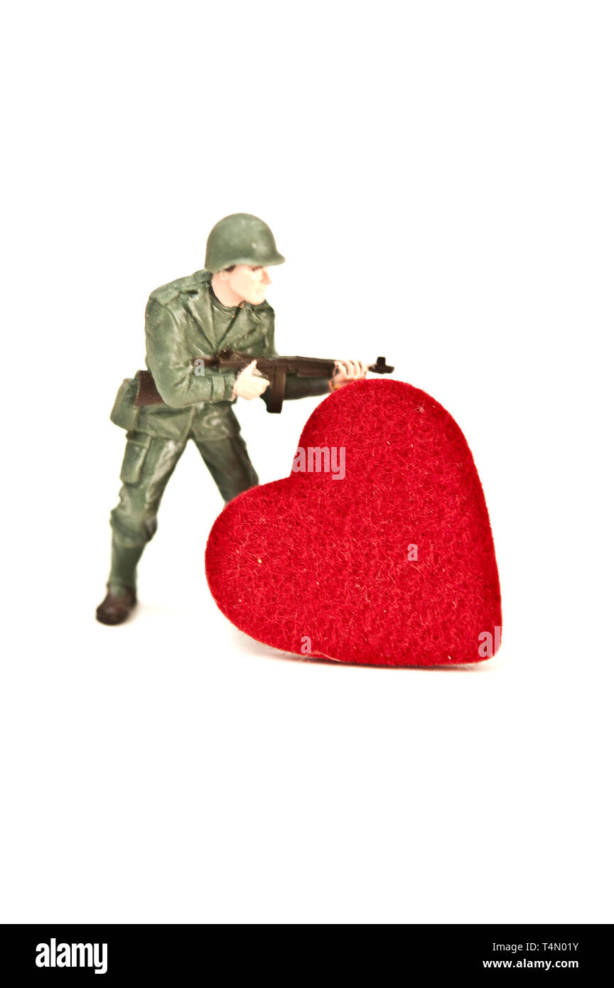 Giocattolo di plastica soldato e forma di cuore, fanno di non amare il concetto di guerra Foto Stock