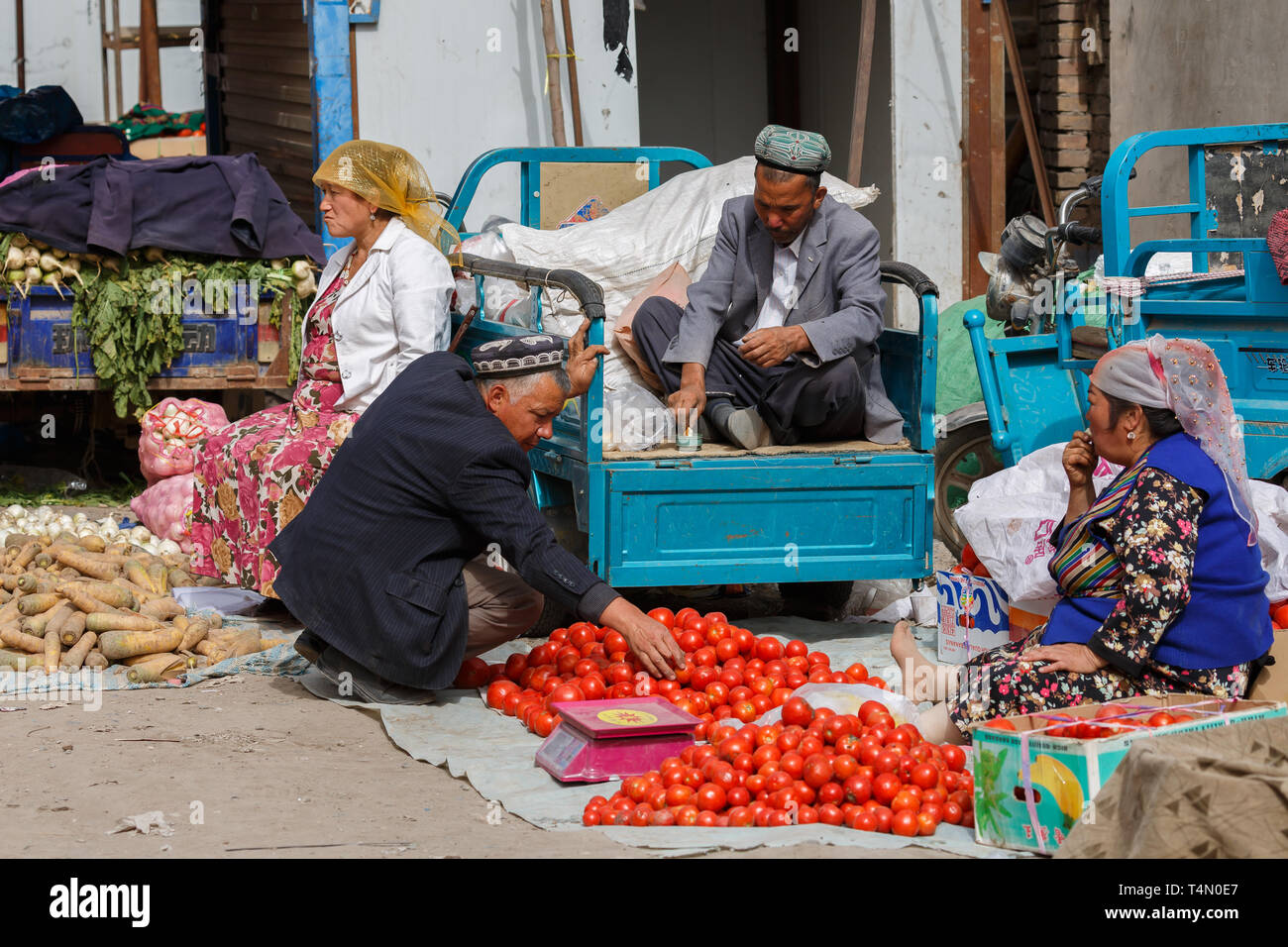 KASHGAR, XINJIANG / Cina - Ottobre 1, 2017: Scena con quattro anziani Uyghur gli uomini e le donne in attesa per i clienti presso un bazaar di Kashgar. Foto Stock