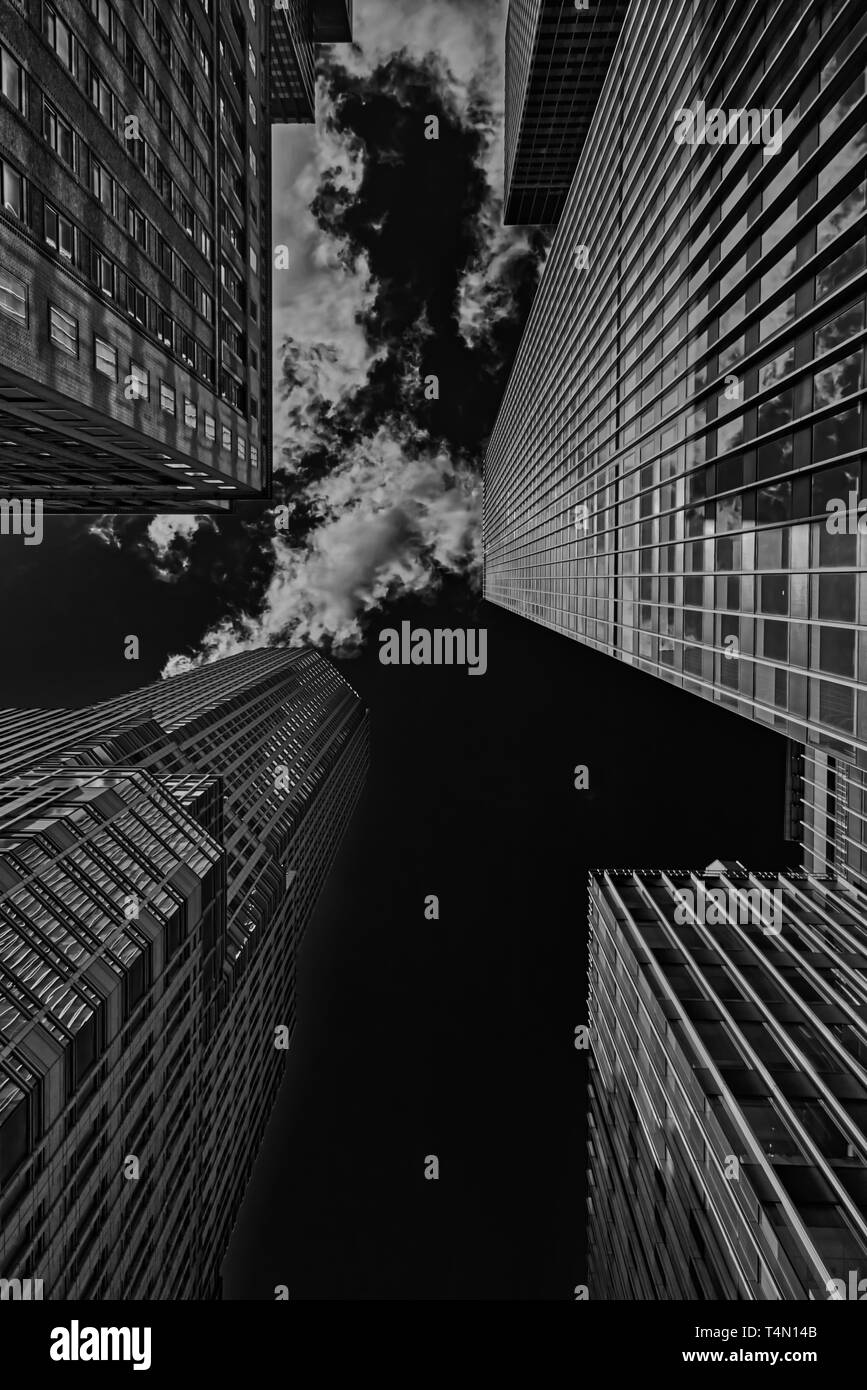 Bassa vista sui grattacieli di Manhattan in bianco e nero con le nuvole in background. Foto Stock