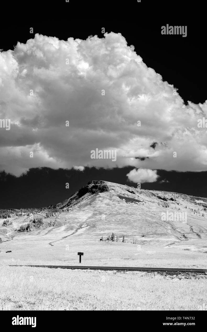 Cielo nero con soffici cloud, frosty campi e collina sottostante. Foto Stock