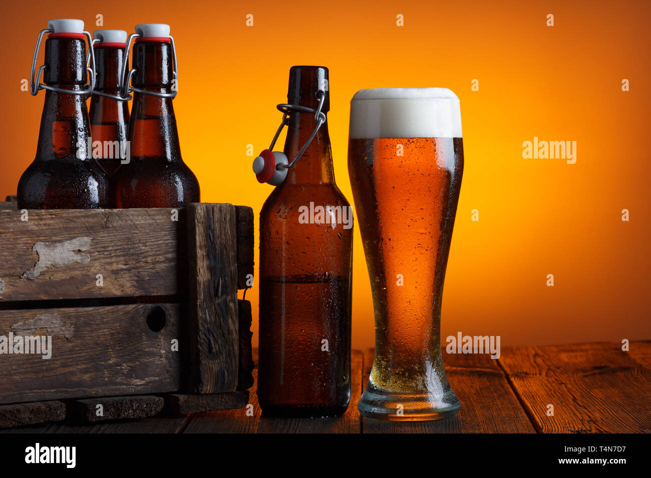 Bicchiere da birra con gabbia in legno pieno di bottiglie di birra sul tavolo Foto Stock
