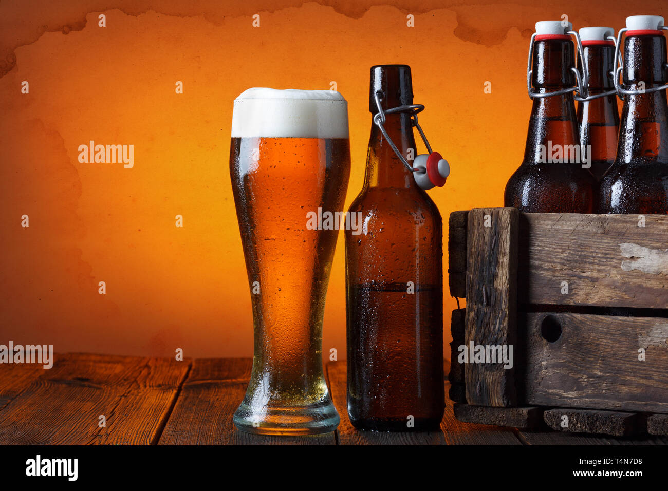 Bicchiere da birra con gabbia in legno pieno di bottiglie di birra sul tavolo Foto Stock