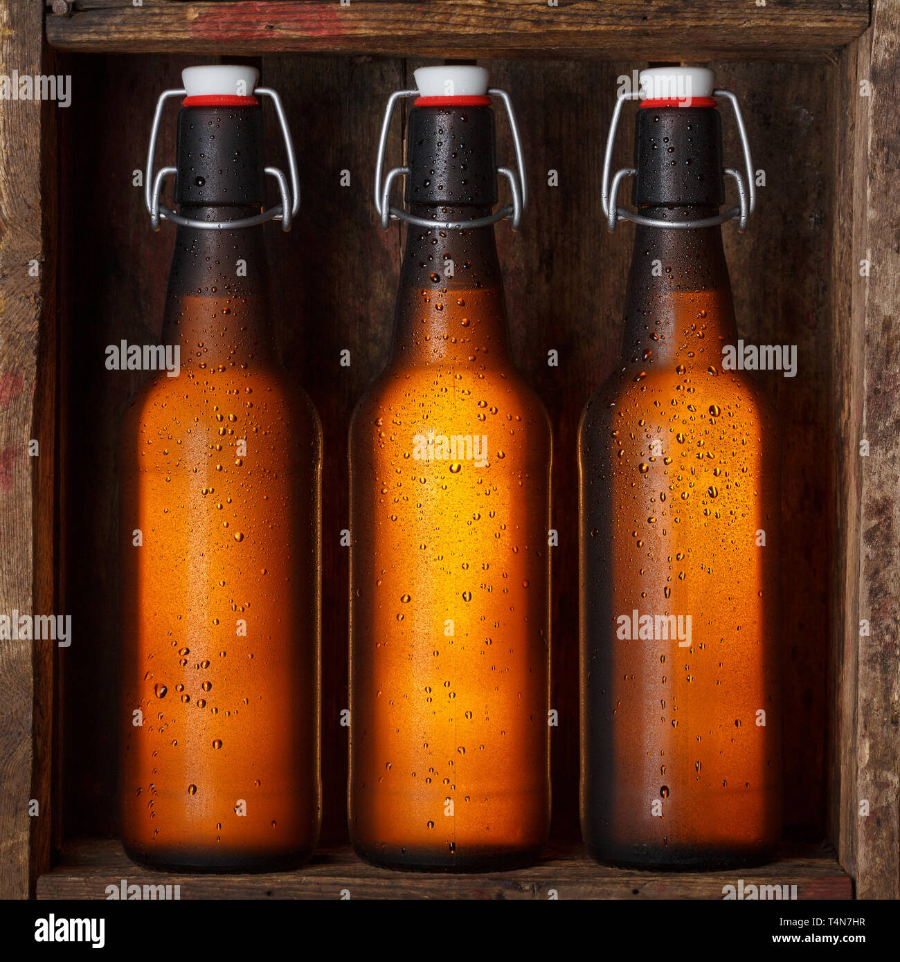 Le bottiglie di birra con vintage swing tops nella vecchia gabbia in legno ancora vita Foto Stock