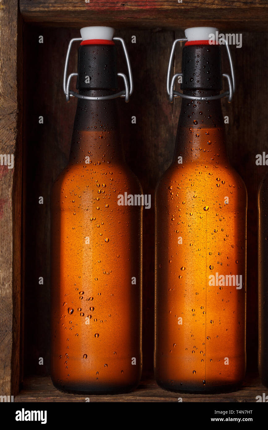 Le bottiglie di birra con vintage swing tops nella vecchia gabbia in legno ancora vita Foto Stock
