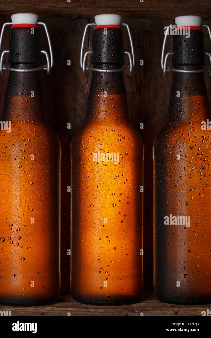 Le bottiglie di birra con vintage swing tops nella vecchia gabbia in legno ancora vita Foto Stock