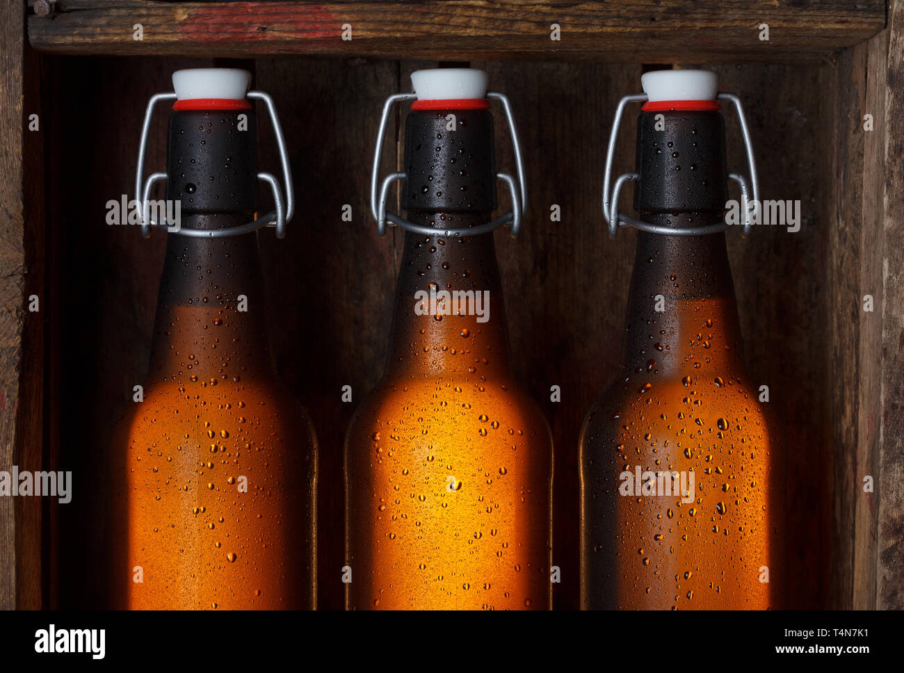 Le bottiglie di birra con vintage swing tops nella vecchia gabbia in legno ancora vita Foto Stock