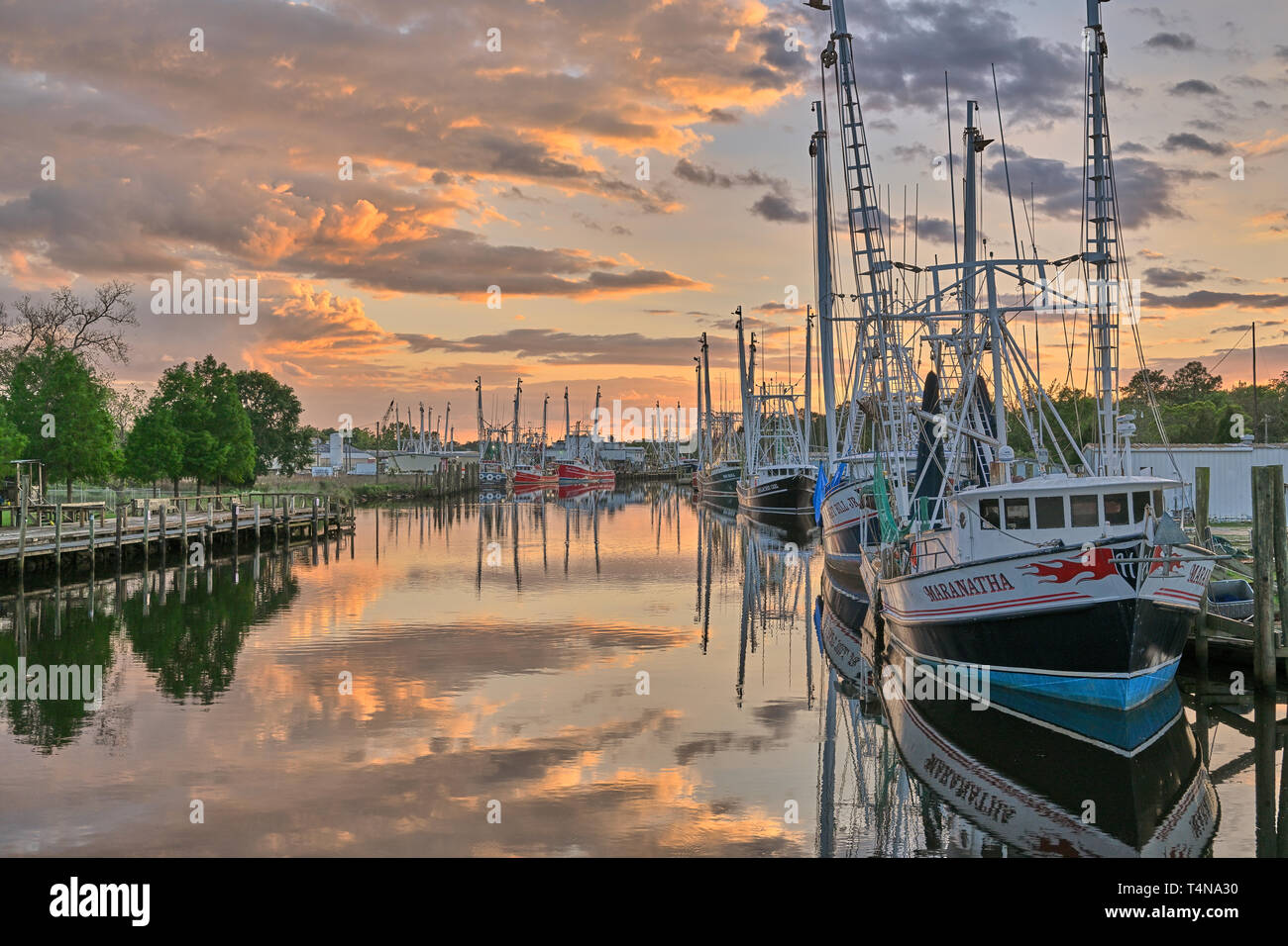 La pesca commerciale di imbarcazioni e natanti adibiti alla pesca di gamberetti legato fino al tramonto in Bayou La Batre Alabama, Stati Uniti d'America. Foto Stock