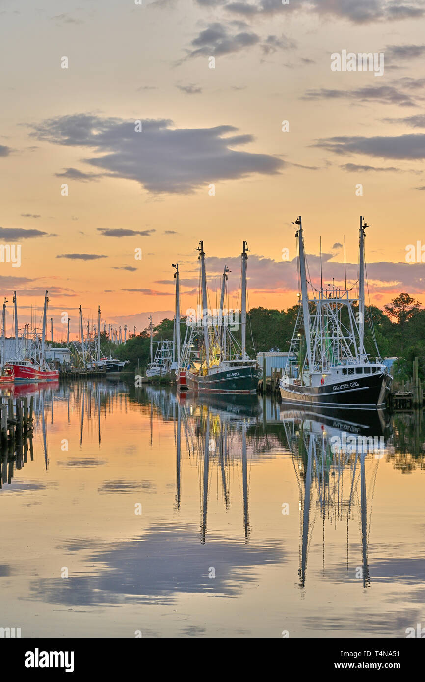La pesca commerciale di imbarcazioni e natanti adibiti alla pesca di gamberetti legato fino al tramonto in Bayou La Batre Alabama, Stati Uniti d'America. Foto Stock