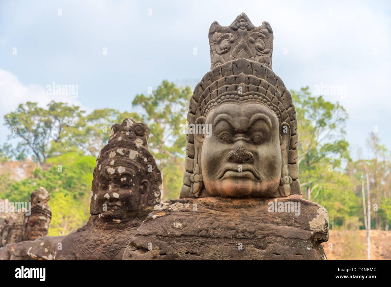 Antiche statue indù lungo i lati del ponte sud in Angkor Thom tempio chiudere la parte di Angkor Wat parco archeologico, Siem Reap in Cambogia Foto Stock
