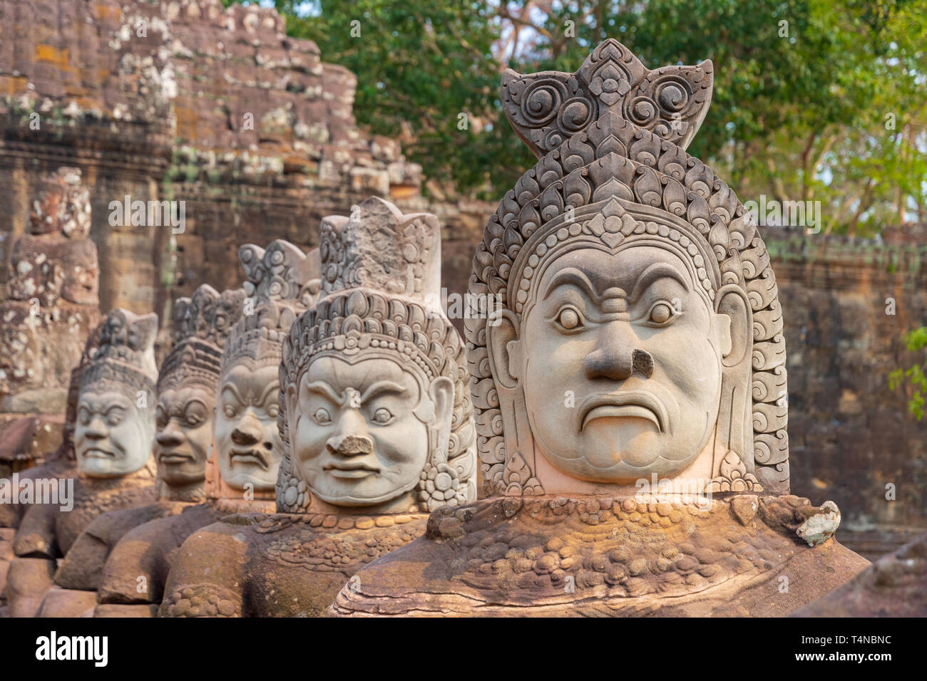 Antiche statue indù lungo i lati del ponte sud in Angkor Thom tempio chiudere la parte di Angkor Wat parco archeologico, Siem Reap in Cambogia Foto Stock
