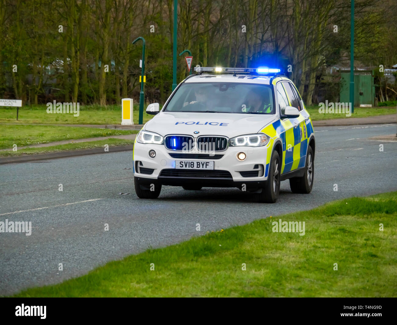 Una BMW pattuglia di polizia a velocità di lampeggio luci blu in un territorio rurale trunk road nel North Yorkshire Foto Stock