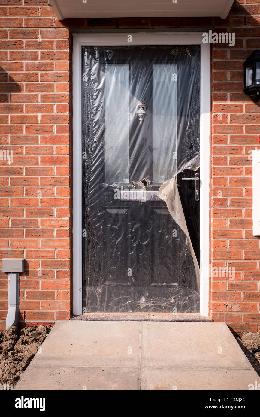 La porta anteriore di una nuova casa, ancora avvolti in teli di plastica Foto Stock