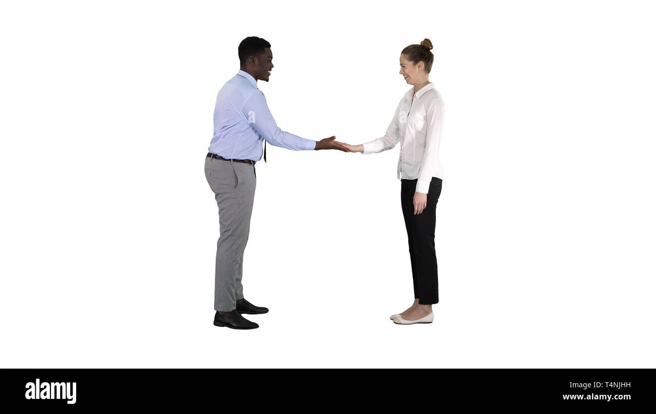 Lunghezza intera. Africana di uomo e donna caucasica dando bassa cinque su sfondo bianco. Professional shot in risoluzione 4K. 012. È possibile utilizzare ad esempio nella vostra Foto Stock