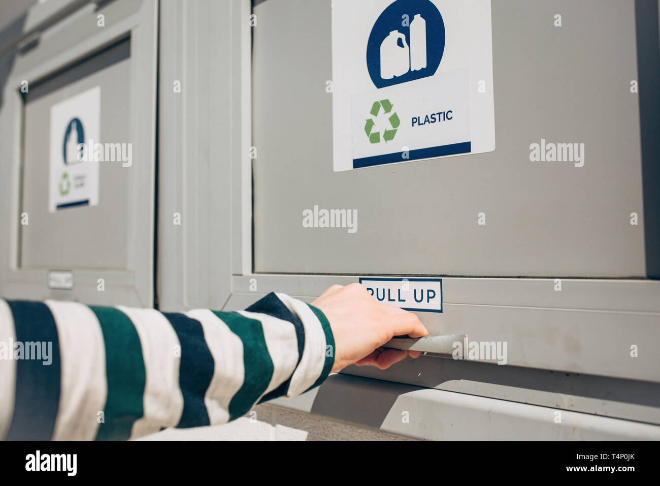 Una persona che si apre o si chiude un moderno bidone dei rifiuti per la raccolta differenziata dei rifiuti. Foto Stock