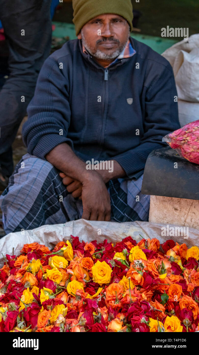 Ritratto verticale di un uomo vendere rose a fiore Mattuthavani mercato in Madurai, India. Foto Stock