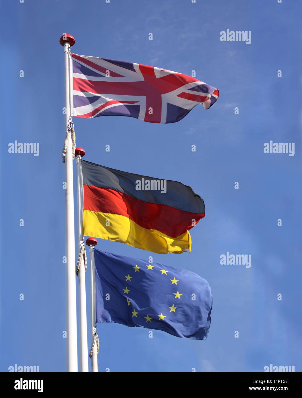 Le bandiere provenienti da Inghilterra, Regno Unito e Germania sventolare dai pennoni insieme con l'Unione europea, Unione europea, bandiera contro un cielo blu. Foto Stock