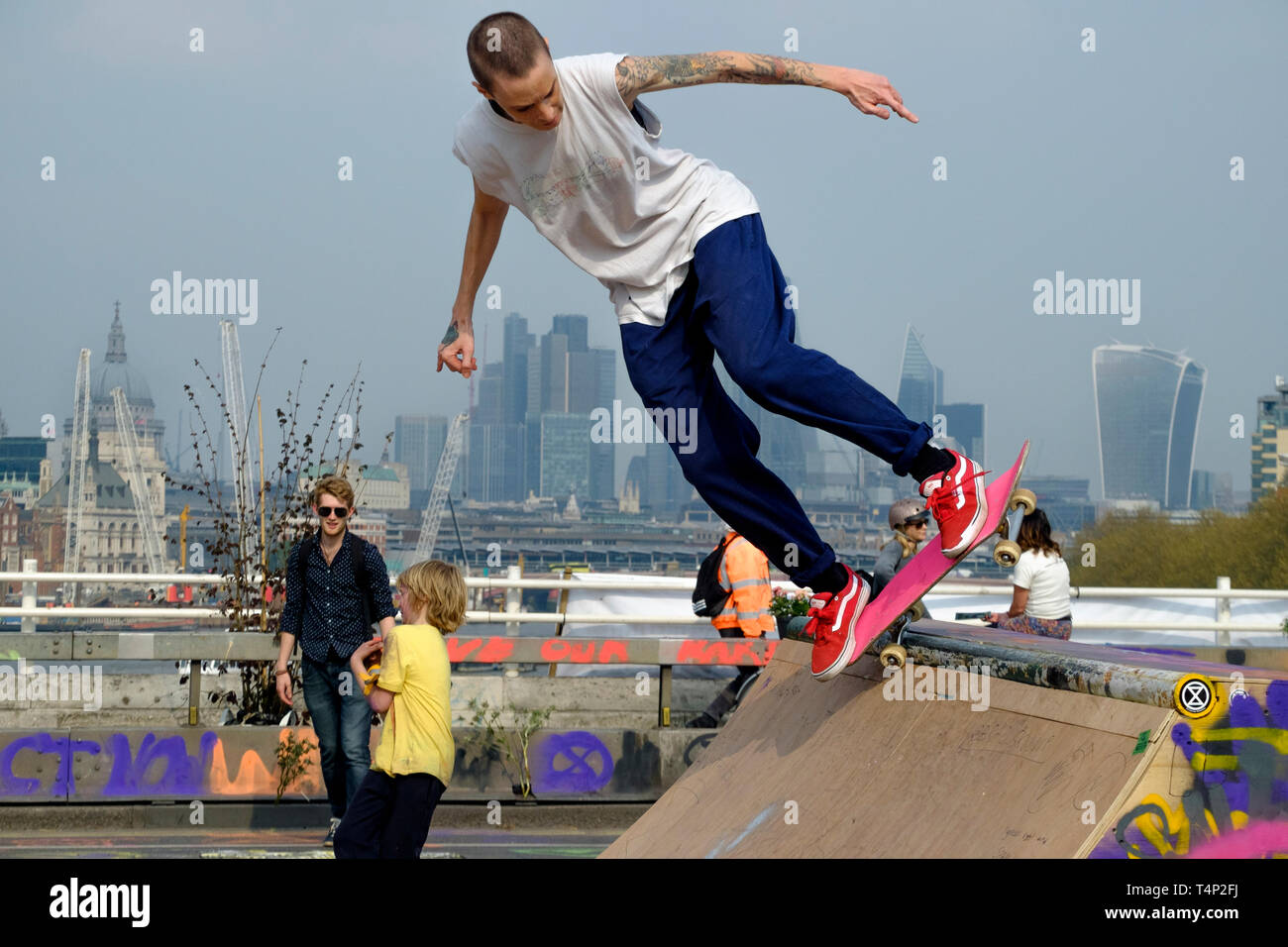 Skateboarder sullo sfondo della città di Londra durante l'occupazione della ribellione di estinzione del ponte di Waterloo, aprile 2019. Foto Stock