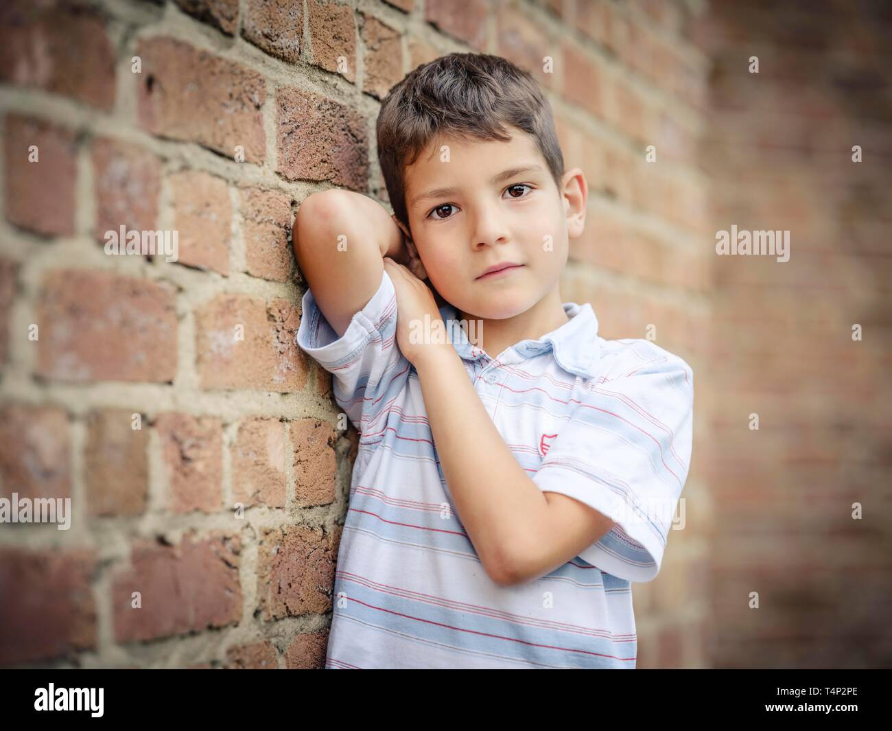 Il ragazzo, 7 anni, appoggiata contro una parete verticale, Germania Foto Stock