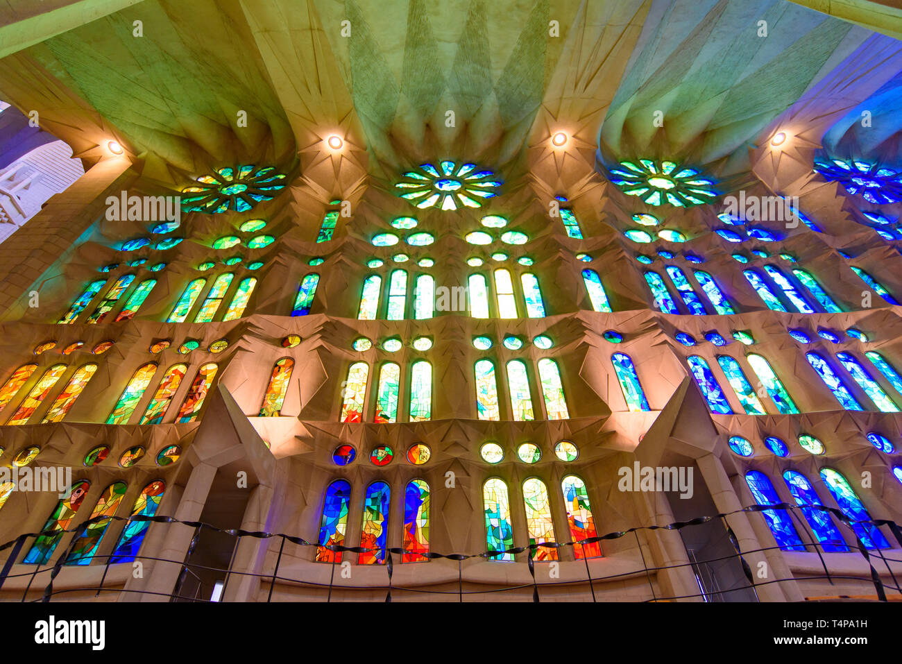 La luce attraverso la colorata vetrata della Sagrada Familia (Chiesa della Sacra Famiglia), la cattedrale progettata da Gaudì a Barcellona, Spagna Foto Stock