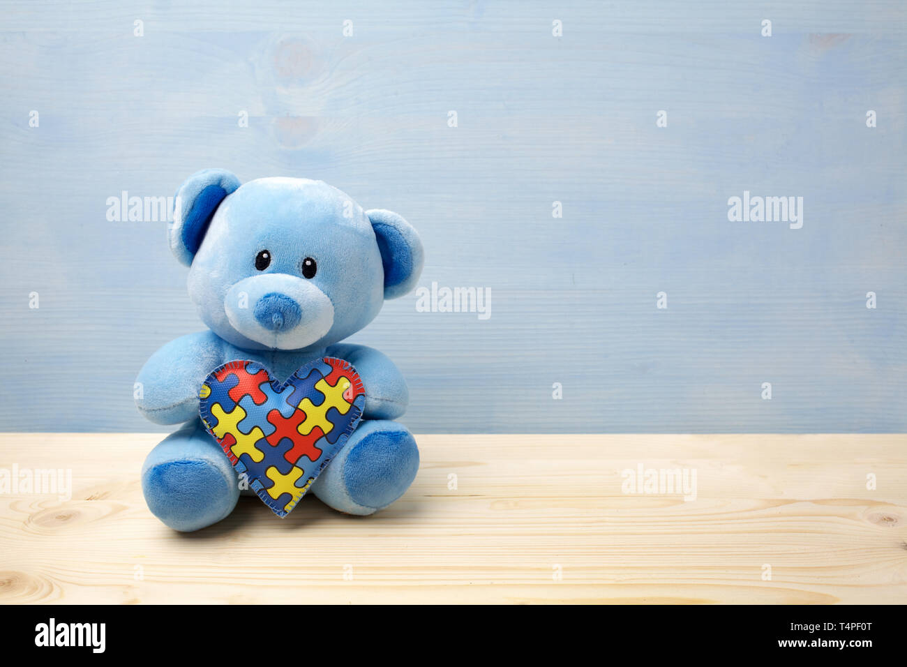 Mondo autismo giornata di sensibilizzazione, concetto con Teddy bear holding o puzzle jigsaw pattern sul cuore Foto Stock