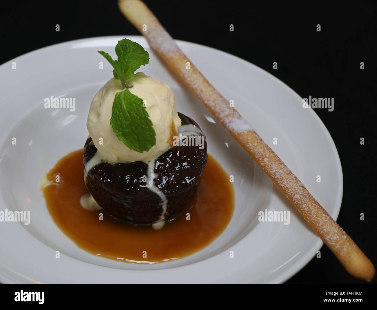Sticky toffee pudding con gelato alla vaniglia e salsa di caramello Foto Stock