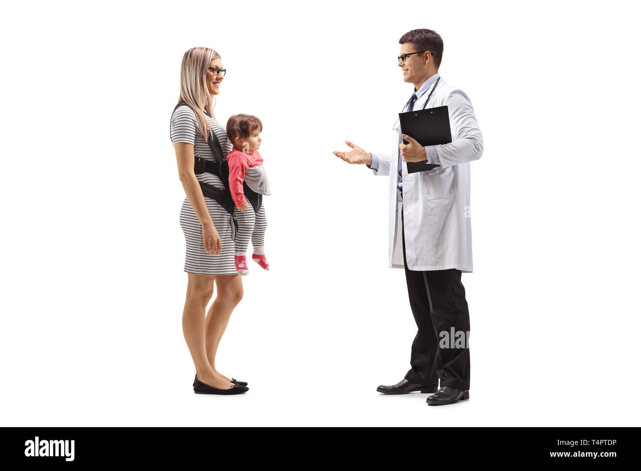 A piena lunghezza shot di una madre con un bambino in un carrier di parlare ad un medico di sesso maschile isolato su sfondo bianco Foto Stock