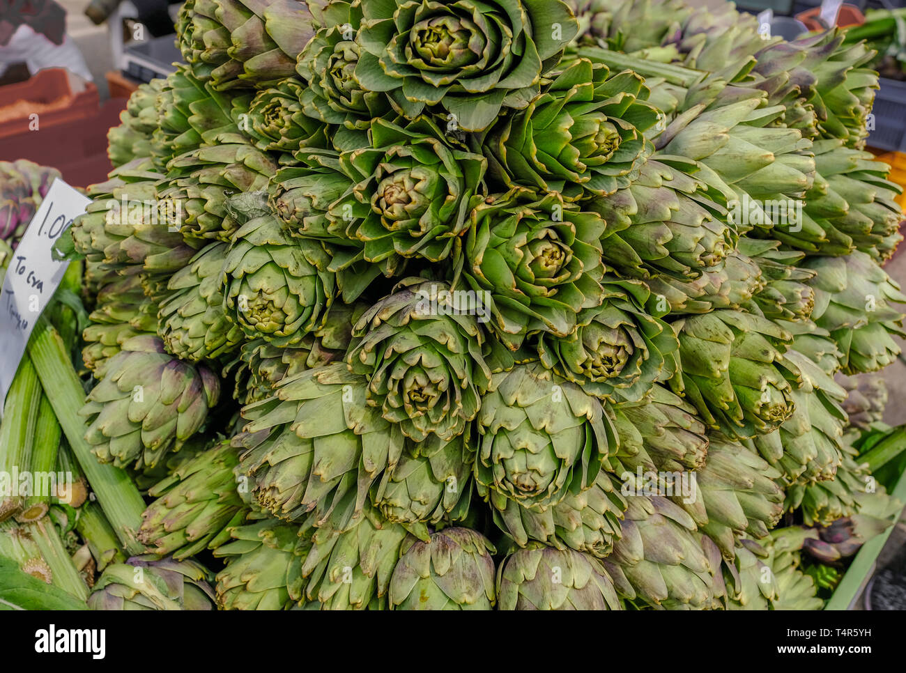 Display del carciofo è in vendita su un mercato in stallo. Impilati e tutte rivolte in avanti. Foto Stock