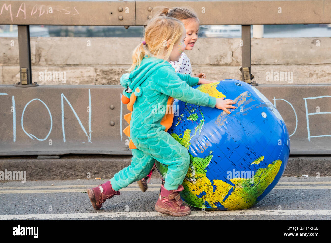 Londra, Regno Unito. 18 apr 2019. I bambini godono di spingendo una versione gonfiabile del loro mondo verso il basso il ponte - Sera e l'atmosfera del festival ritorna - Giorno 4 - i manifestanti dalla ribellione di estinzione blocco più giunzioni a Londra come parte della loro protesta in corso alla domanda di azione da parte del governo del Regno Unito sulle "clima chrisis'. L'azione è parte di un internazionale coordinato di protesta. Credito: Guy Bell/Alamy Live News Foto Stock