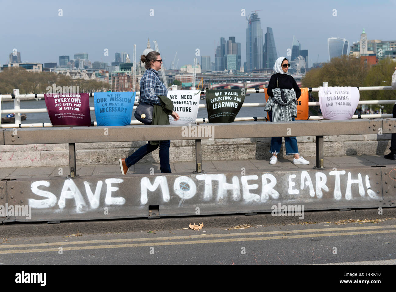 Salvare la madre terra graffiti su Waterloo Bridge realizzata durante la ribellione di estinzione sciopero a Londra. Gli attivisti ambientali dalla ribellione di estinzione movimento tenere premuto per il quarto giorno consecutivo Waterloo Bridge di Londra. Gli attivisti è stato parcheggiato un camion sul ponte bloccando la strada causando interruzioni. Di polizia sono stati arresto di manifestanti che si rifiutano di testa a Marble Arch. Estinzione della ribellione esige dal governo di azioni dirette sul clima, ridurre a zero le emissioni di carbonio nel 2025 e un gruppo di popoli. Foto Stock