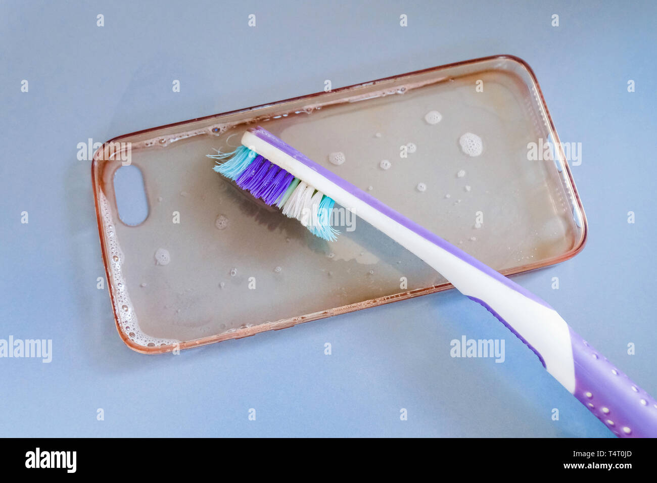 Pulizia del silicone Custodia per telefono con uno spazzolino da denti, e schiuma di sapone Foto Stock