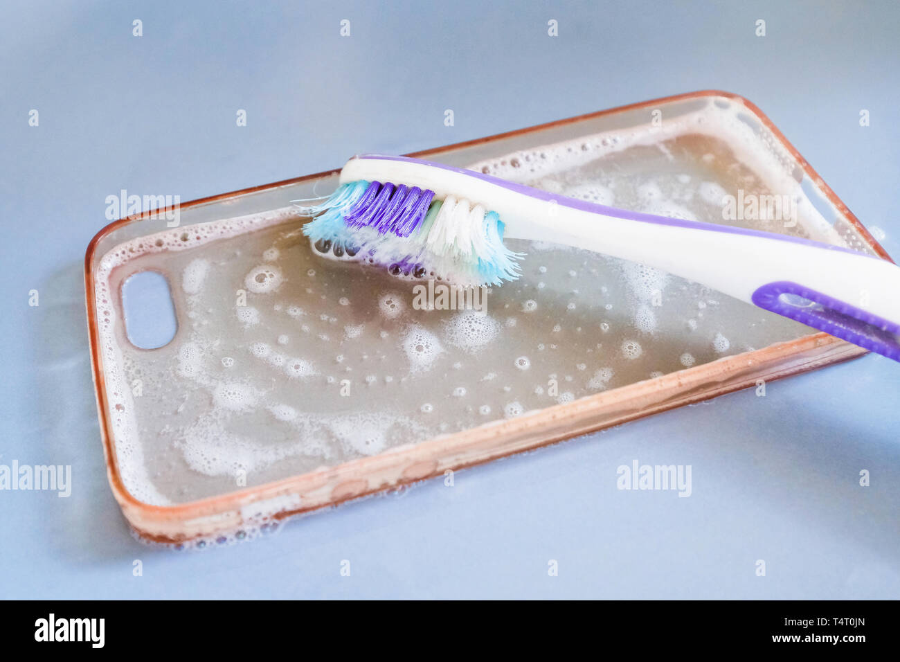 Pulizia del silicone Custodia per telefono con uno spazzolino da denti, e schiuma di sapone Foto Stock