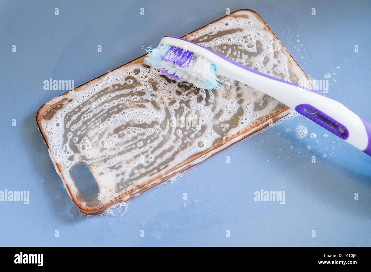 Pulizia del silicone Custodia per telefono con uno spazzolino da denti, e schiuma di sapone Foto Stock