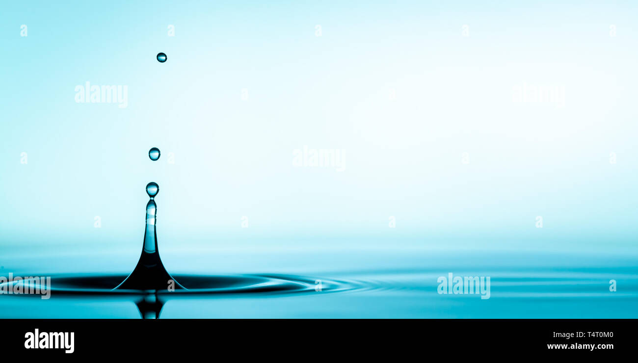 Pulire con acqua blu di spruzzi di goccioline nella pozzanghera con increspature Foto Stock