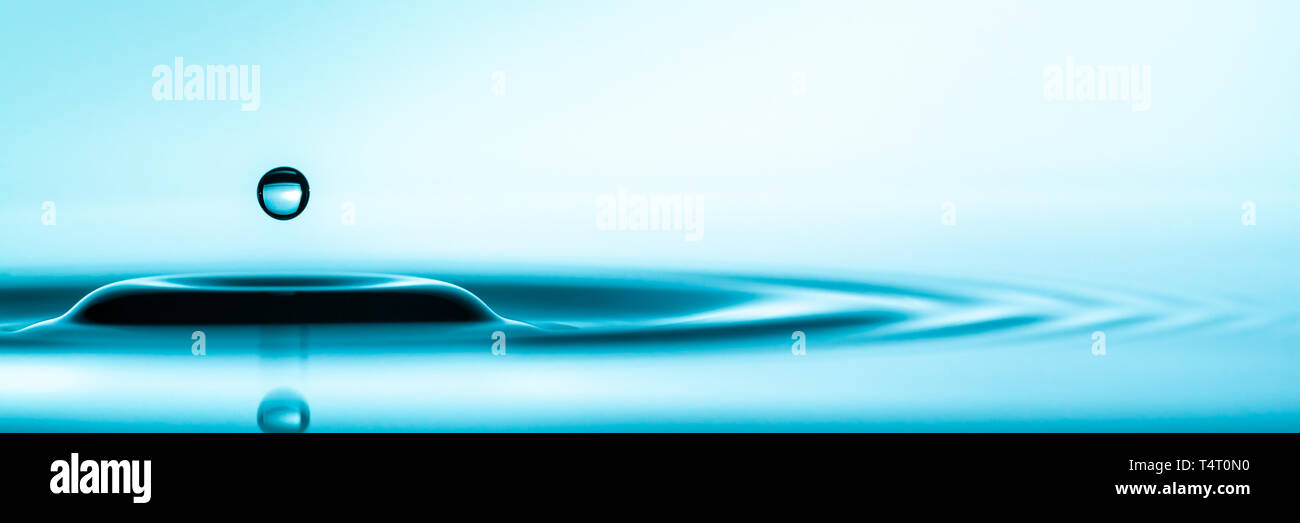 Pulire con acqua blu di spruzzi di goccioline nella pozzanghera con increspature Foto Stock