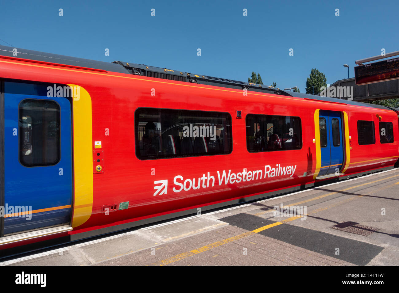 A South Western convoglio ferroviario trasporto in attesa in banchina della stazione a Londra, Regno Unito. Foto Stock