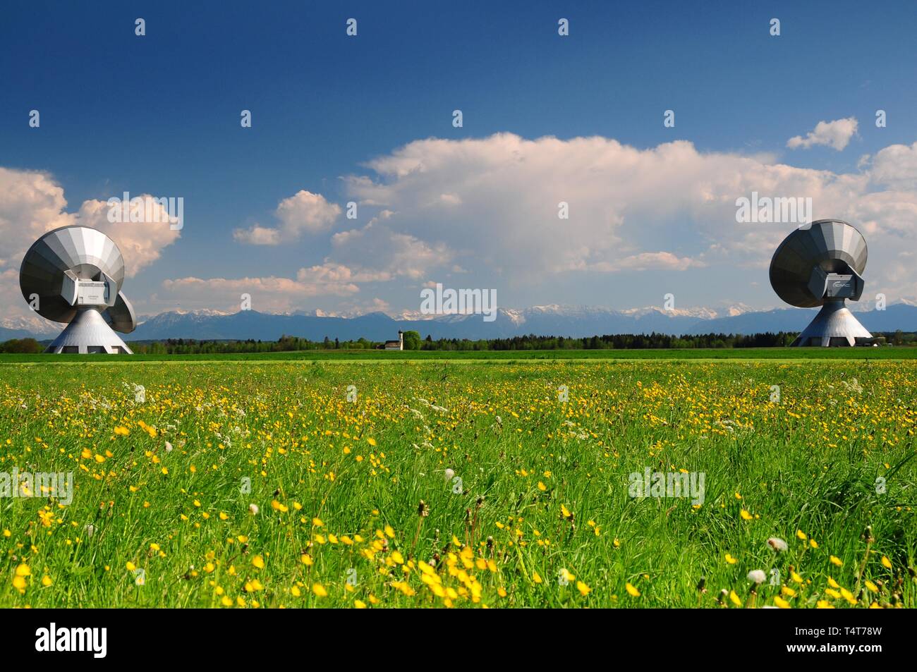 Sankt Johann im Felde, incorniciato dalle antenne paraboliche della stazione di terra, vicino Raisting, Alta Baviera, Weilheim / Schongau, sullo sfondo delle Alpi Bavaresi, Baviera, Germania, Europa Foto Stock