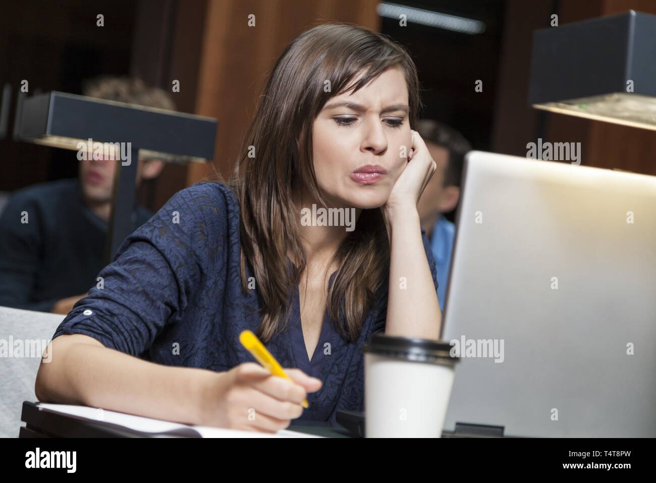 Studenti che lavorano su computer portatile in biblioteca Foto Stock