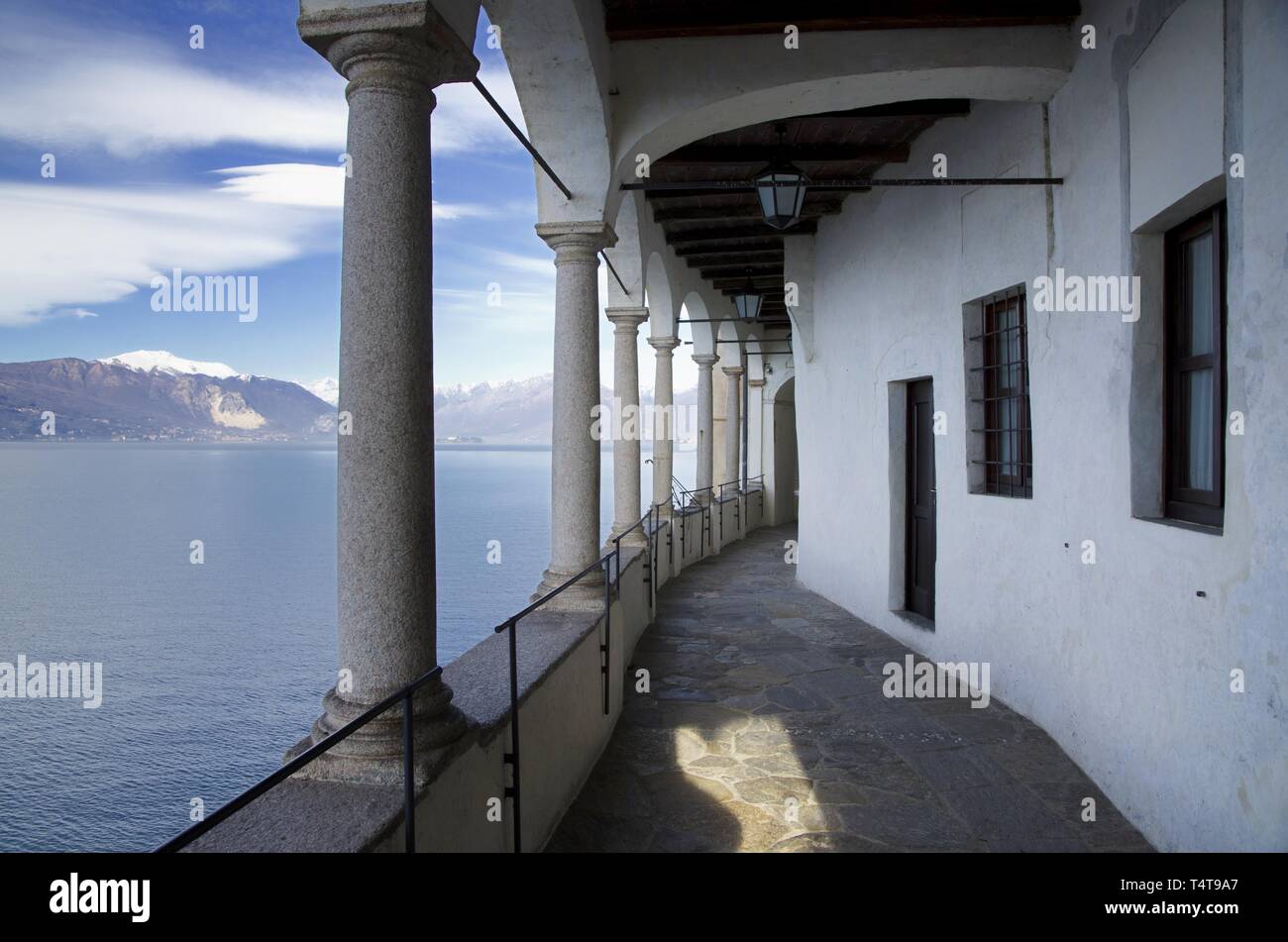 Eremo di Santa Caterina del Sasso sul Lago Maggiore con Snow-capped Mountain a Leggiuno in Lombardia, Italia. Foto Stock