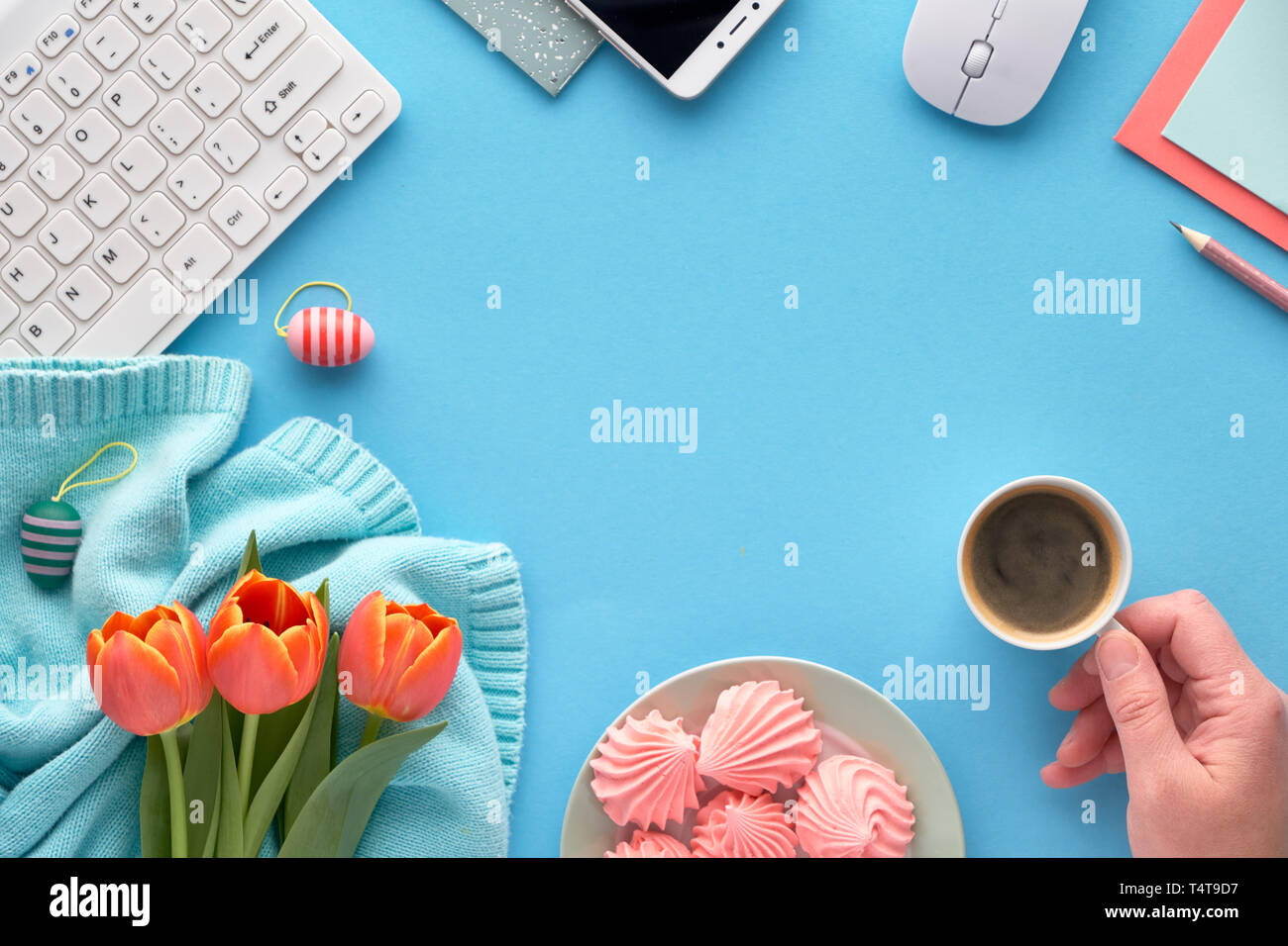 Tulipani rosa su mint colorato Maglione cotone, cartoline e buste, tastiera, telefono cellulare, piastra di marshmallow e tazza di caffè. Piatto sui laici Foto Stock