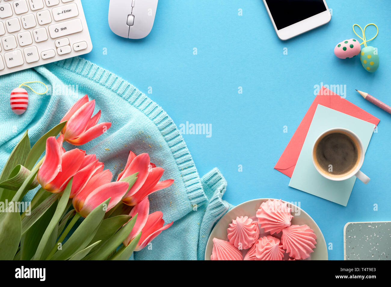 Tulipani rosa su mint colorato Maglione cotone, cartoline e buste, tastiera, telefono cellulare, piastra di marshmallow e tazza di caffè. Piatto sui laici Foto Stock