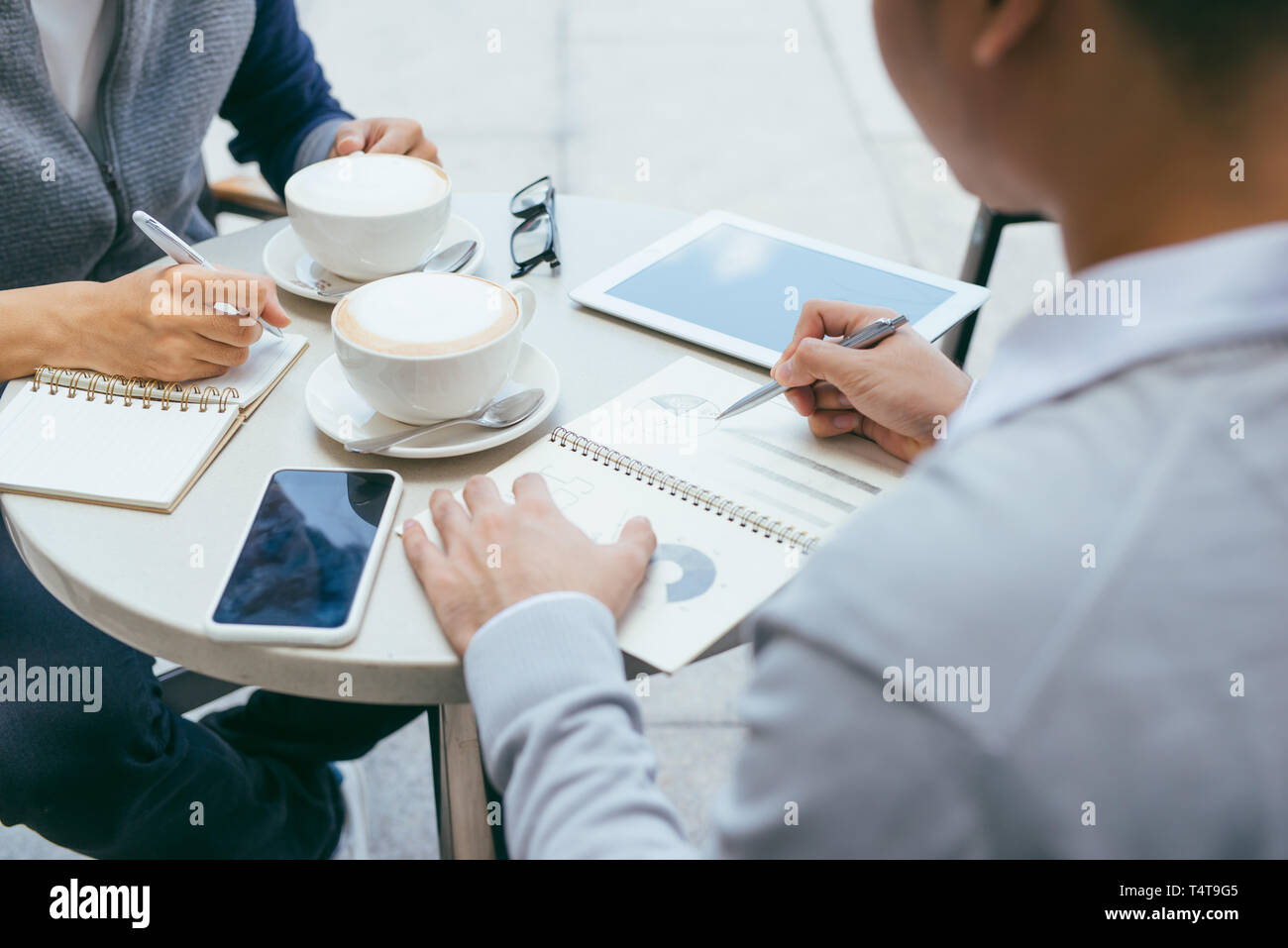 Controllo delle scorte. Due business partner di lavoro sul computer che sorride allegramente su un incontro presso la caffetteria locale - Immagine Foto Stock