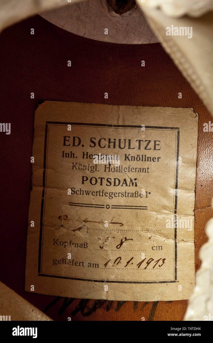 Il principe Oskar di Prussia (1888 - 1958) - un casco come ufficiale il 1° pedale di reggimento di guardia, corpo fatto di nero in pelle di brevetto (fragili), argento i raccordi. Eagle emblema con applicato, smaltato guard star ('Suum Cuique'), sormontato dal banner script 'semper Talis', chinscales piana sulla quale ufficiale di cockades, alto picco di scanalati (unscrewable), Anello perla, corona circolare la piastra con le viti a stella. Di seta bianca e fodera in pelle bianca Fascia assorbisudore, all'interno del corpo etichetta del costruttore "Ed. Schultze, Königl. Hoflieferant, Potsdam'. Casco con coperchio in campo, Additional-Rights-Clearance-Info-Not-Available Foto Stock